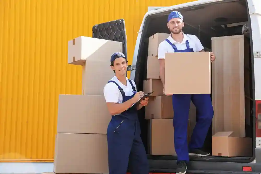 Movers transporting furniture with a modern moving truck.