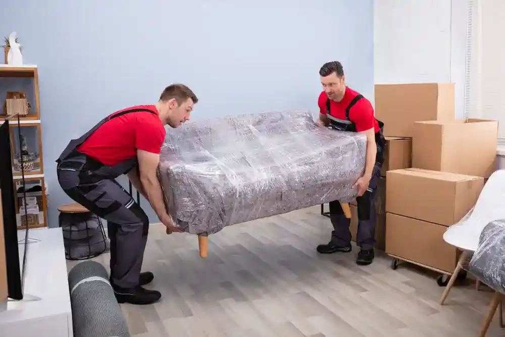 Professional movers securing furniture during a cross-country move.